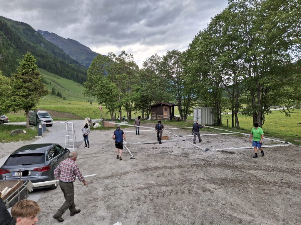 Bogenschütze spannt Jagdbogen auf grünem 3D-Parcours im Raurisertal vor Bergkulisse