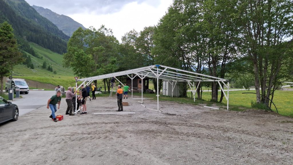 Bogenschütze spannt Jagdbogen auf grünem 3D-Parcours im Raurisertal vor Bergkulisse