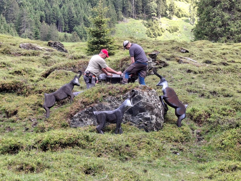 Bogenschütze zielt mit traditionellem Jagdbogen im grünen 3D-Parcours des Raurisertals