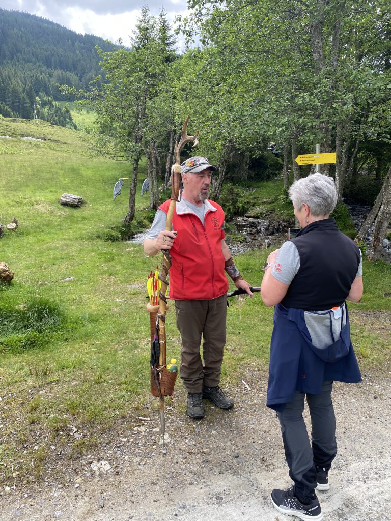 Bogenschütze spannt Jagdbogen vor Waldkulisse im Raurisertal, Outdoor-Bogensport-Parcours