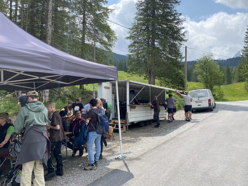 Bogenschütze spannt Jagdbogen auf grünem 3D-Parcours im Raurisertal vor Bergkulisse