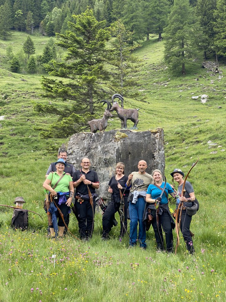Bogenschütze spannt Jagdbogen auf grünem 3D-Parcours im Raurisertal vor Bergkulisse