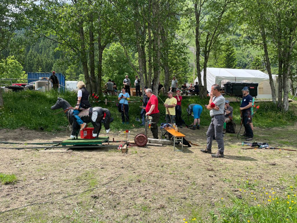 Bogenschütze spannt Jagdbogen im Waldparcours, Naturkulisse Raurisertal, Outdoor-Aktivität