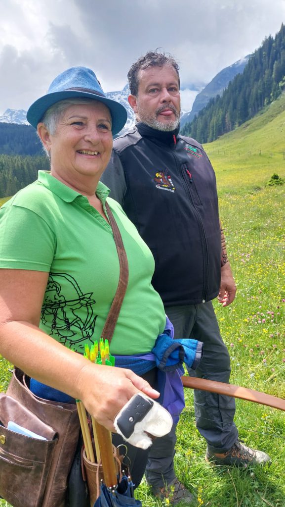 Bogenschütze spannt Jagdbogen auf grünem 3D-Parcours im Raurisertal vor Bergkulisse