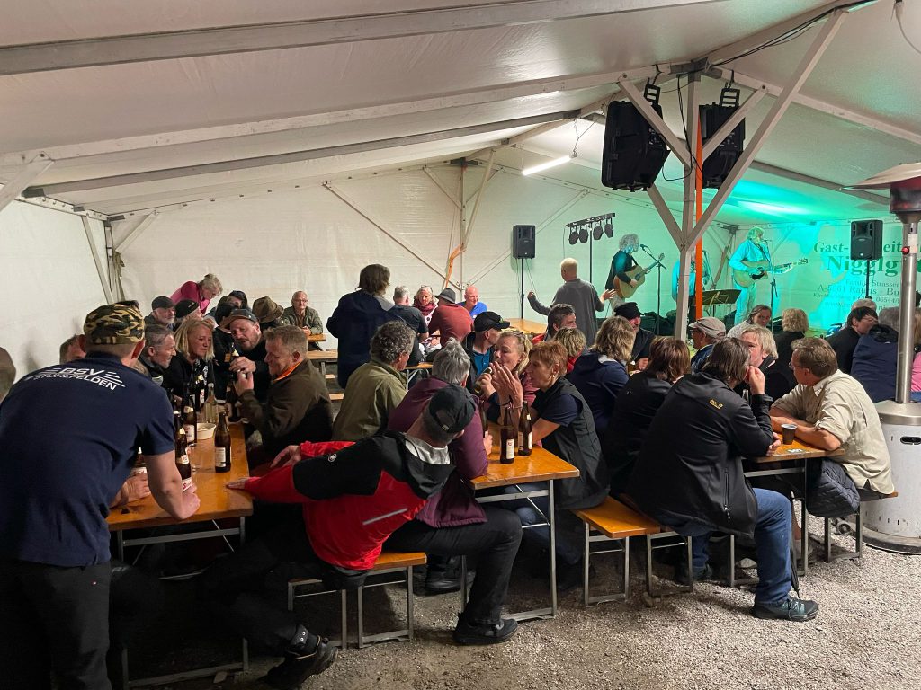 Bogenschütze spannt Jagdbogen auf grünem 3D-Parcours im Raurisertal vor Alpenpanorama